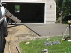 Akerly Concrete Construction putting the finishing touches on a new concrete driveway with an expanded, textured parking area.